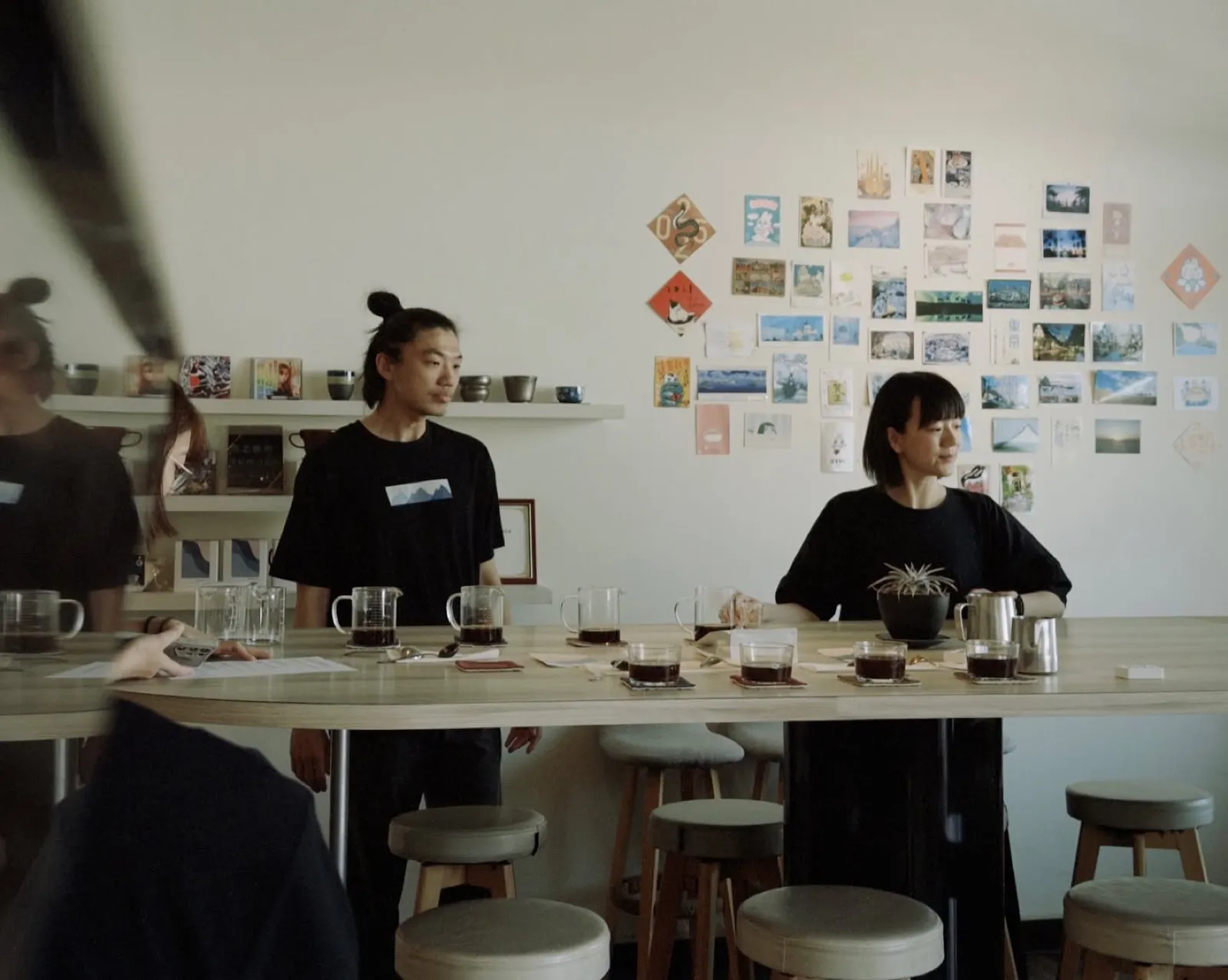 店內長桌上的杯測，背景是明信片牆